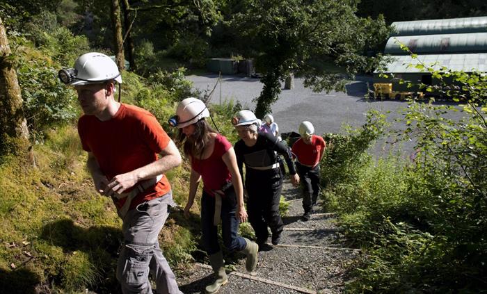 People setting off up steps to a dark Victorian drift mine